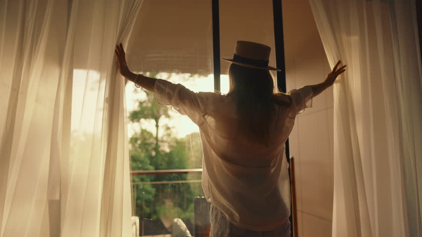 Be happy and enjoy summer, joyful female tourist admiring garden through window. Calmness and solitude in beautiful tropical country, young adult woman enjoying life and moments, single traveler
