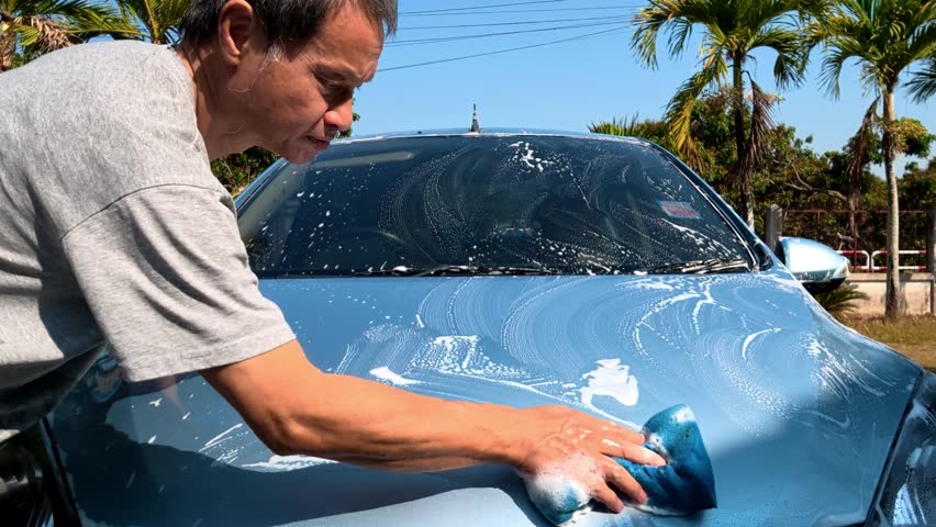 A man is washing his car, out door Chiangmai Thailand.