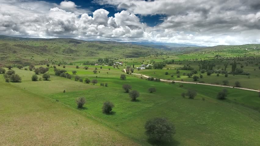 Aerial view of France agriculture farmland with dirt village road through green fields countryside. European farming terrain showing soil track between verdant plains pastoral region.