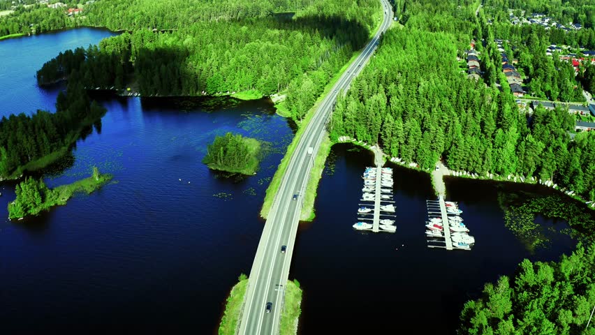 Aerial View of Lush Green Landscape with Highway and Scenic Lake Marina in Summer in Finland