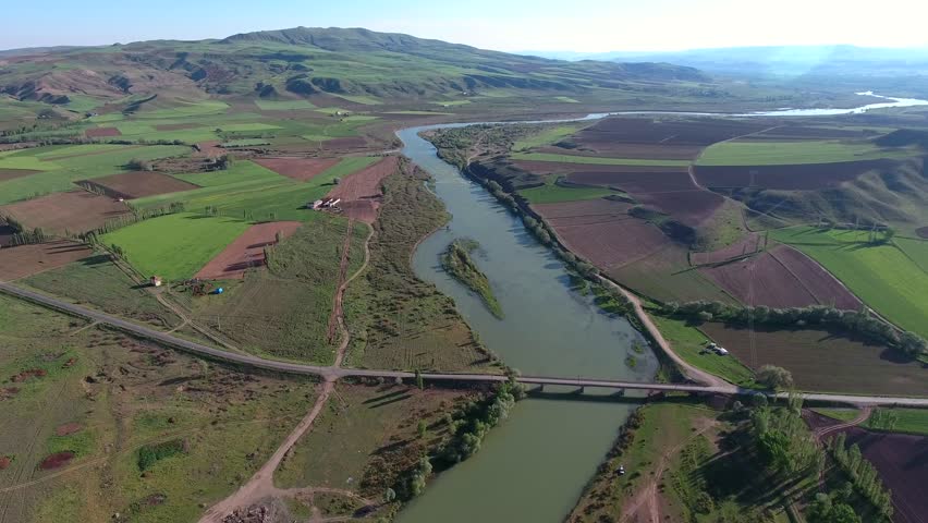 Aerial view of Mississippi River in USA America winding beside green farmland plains. Overhead panorama shows vast channel cutting across prairie cropland toward calm northern headwaters.