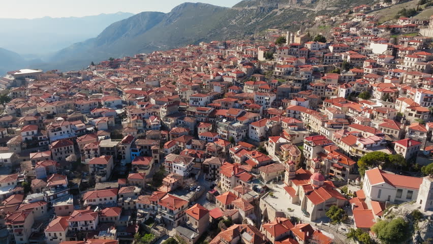 Stunning aerial drone shot of the traditional mountain village Arachova in Greece, featuring red tiled roofs and scenic alpine landscape. Ideal for travel and tourism content.