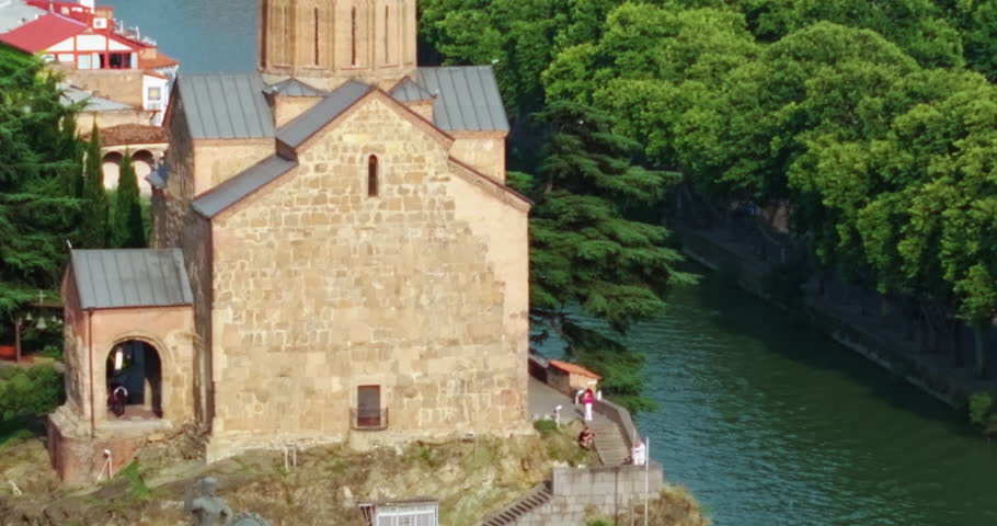 Historic landmarks of Tbilisi: Metekhi Church and Narikala Fortress on a sunny day.