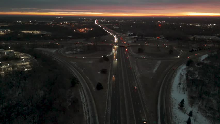 Aerial view of city lights and highway at sunset