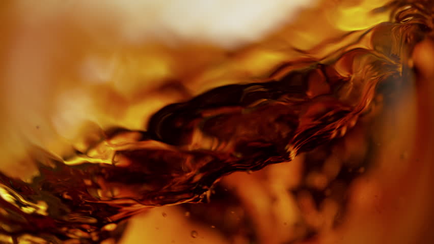 Super Slow Motion Shot of Waving Golden Alcohol Liquid Background at 1000fps.