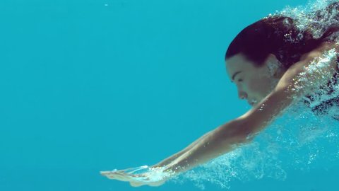 Brunette woman swimming underwater in slow motion