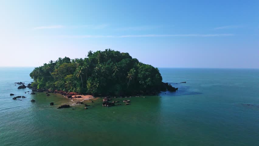Drone aerial view showing Dharmadam Island surrounded by vast open sea. The wide Arabian Sea and soft wave patterns highlight isolation, calmness, and natural coastal beauty.