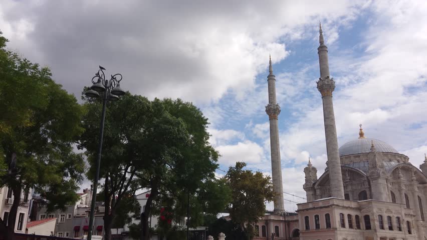 Panning shot of Majestic Ottoman Era Mosque  in Istanbul Turkey and Bosphorus Bridge Scenery Under Gray Sky