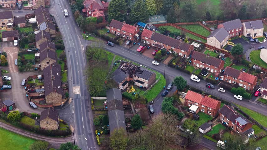 Aerial footage of the village of Spofforth in the county of North Yorkshire England showing an council house that has has a fire showing the burnt roof and timber in a British housing estate
