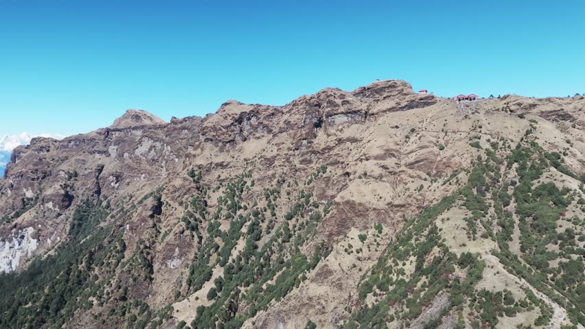 Open high mountains rise above hills with scattered green patches creating a scenic aerial view in Nepal