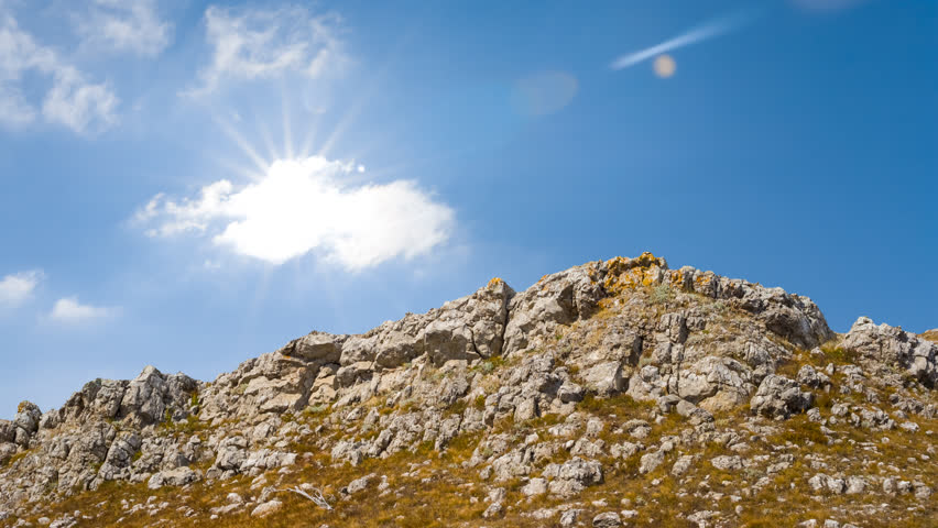 rocky mount top under a sparkle sun, natural outdoor time lapse scene