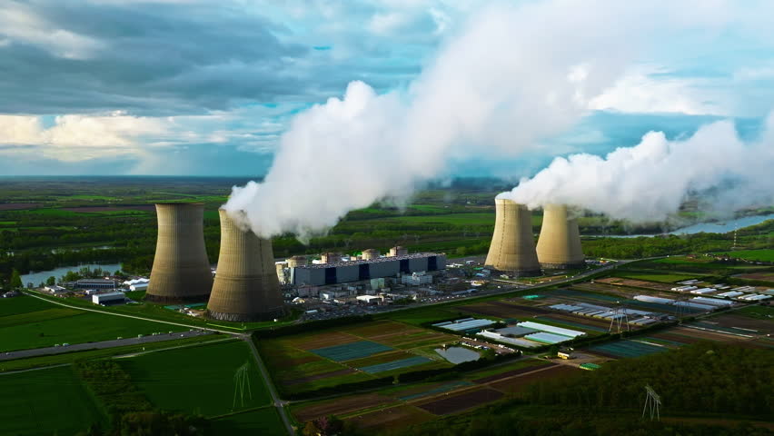 Aerial view nuclear power plant. Steam rises from the huge chimneys of the operating power plant