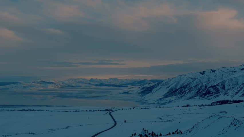 Mono Lake, California with Sierra Nevada snowy mountains reflected across a turquoise saline lake at golden hour, glowing pink, orange, and purple sky over a serene Eastern Sierra desert panorama.