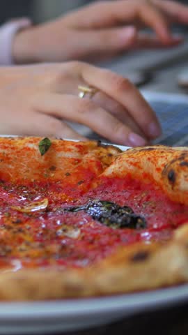 Delicious italian marinara pizza on a white plate with a woman