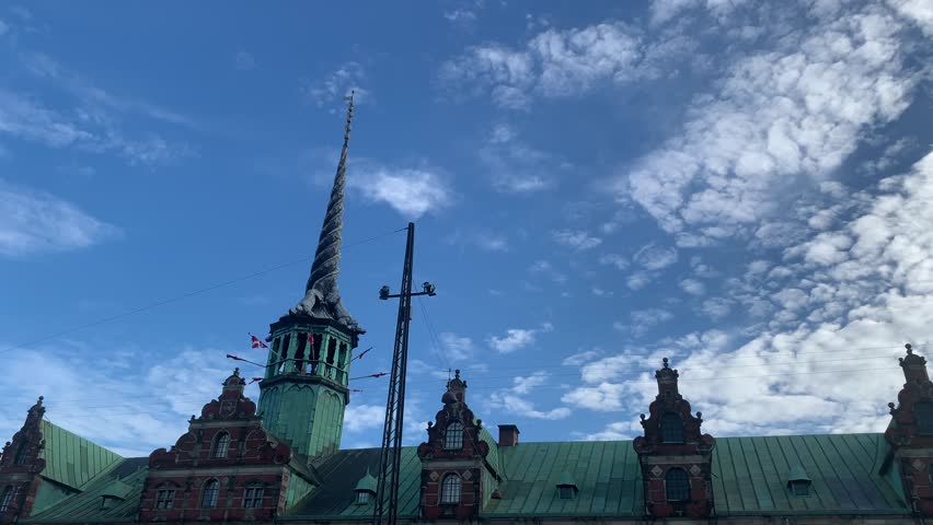 Copenhagen, Denmark – August 2022: View of the historic Børsen building in Copenhagen, featuring the iconic dragon spire rising above the former stock exchange under a blue summer sky