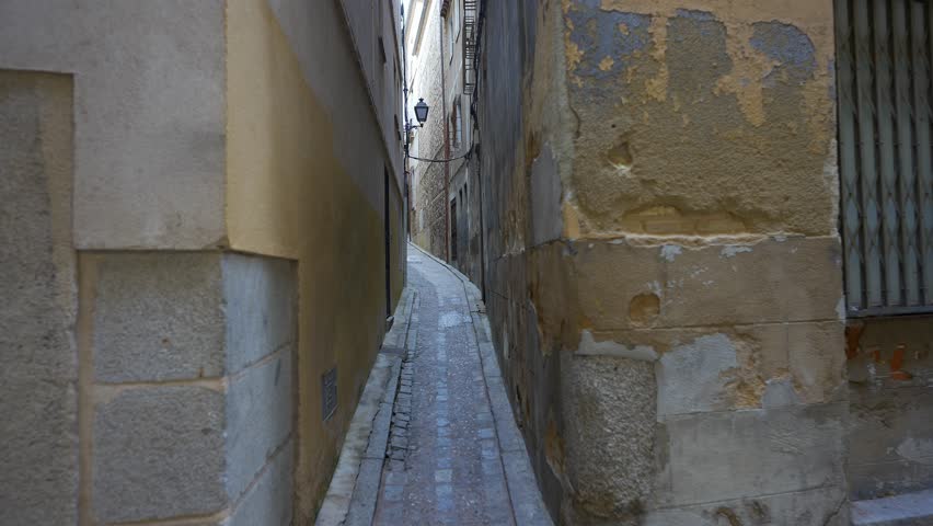 Very narrow street in the old town of the medieval city of Toledo in central Spain.