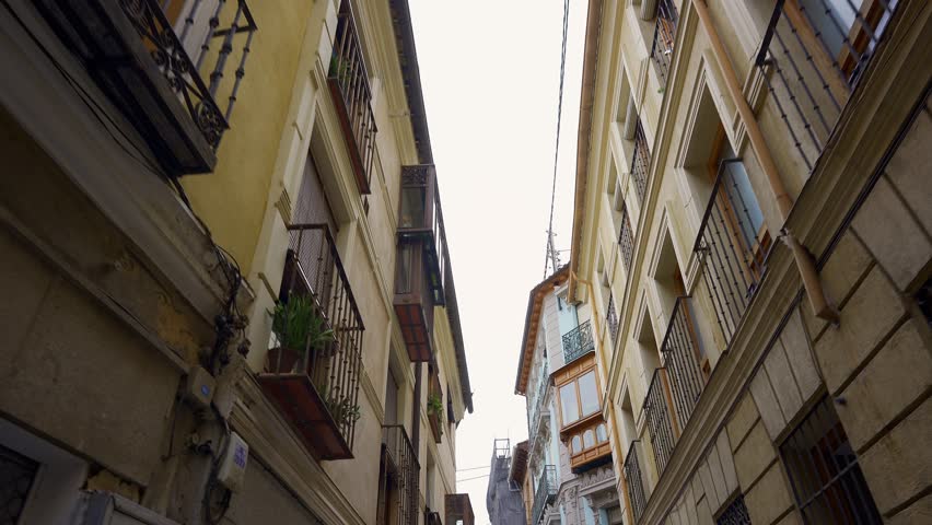 Beautiful facades with balconies and windows in the narrow streets of the city of Toledo, Spain.