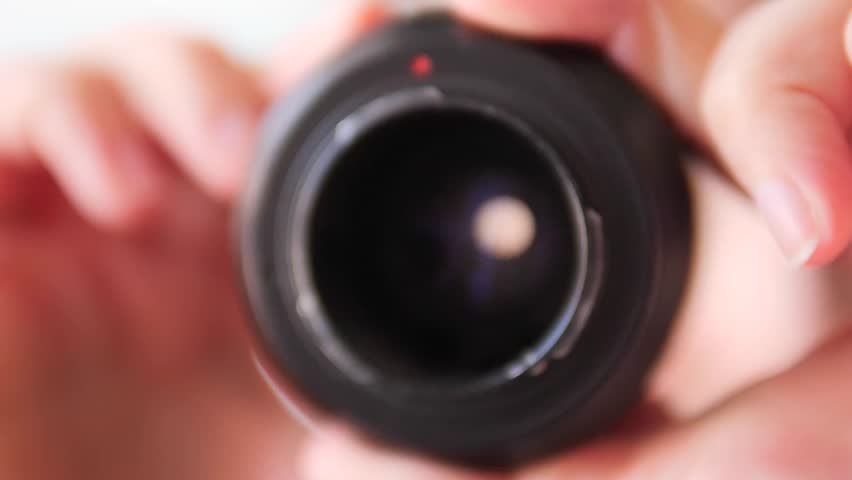 High-magnification internal view of a camera lens during a forward-tracking shot as the aperture iris expands