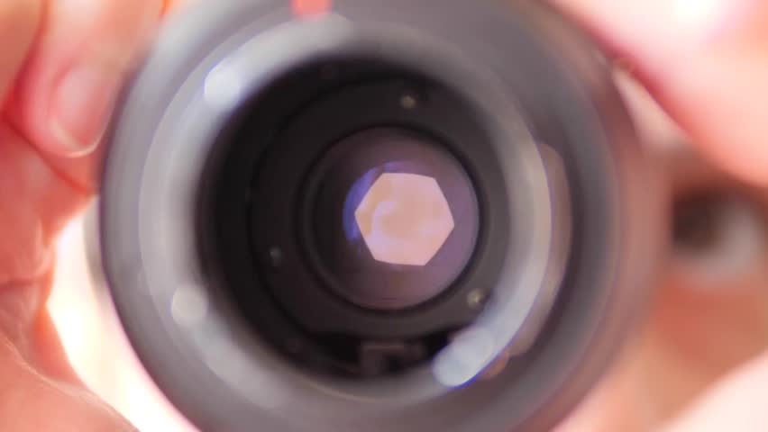 Close-up of camera lens aperture opening wide - Detailed view of lens iris blades expanding