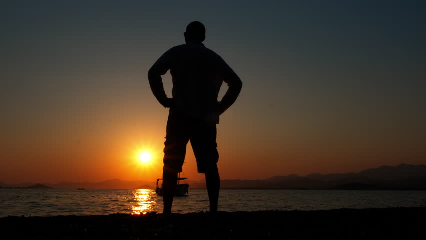 Silhouette of man admiring river dusk. A view of resting man silhouette enjoy the dusk horizon during summer time