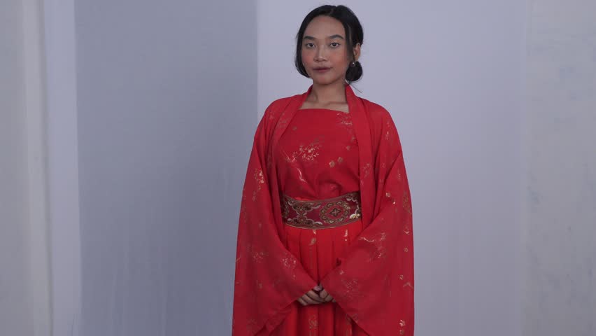 Asian woman dressed in red hanfu smiling in beautiful style