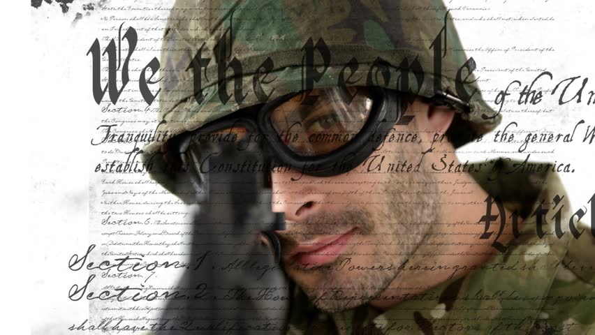 Soldier lifting rifle and aiming centering barrel on camera face blurring over Constitution. Military, camouflage, helmet, goggles, firearm, editorial, stock