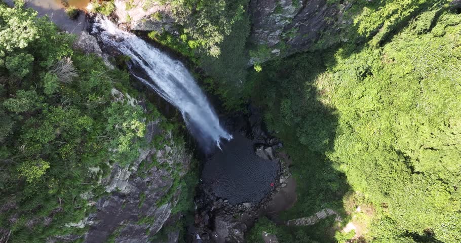 Aerial drone video of Jade Curtain Waterfall (Yu Lian Spring) on Mount Lu, Jiangxi — slow left-rotating descent for dramatic overhead view over cliffs, forest, and cascading water.  