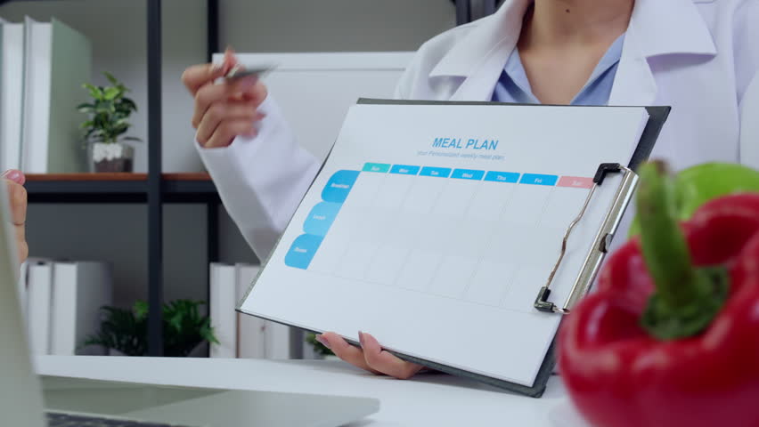 Young asian nutritionist consultation explaining meal plan to patient, doctor guidance meal plan with man, dietitian and patient discussing about nutrient for health, wellness and health advice.