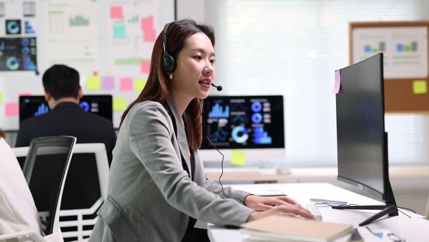 Asian businesswoman working as a telemarketer wearing a headset.