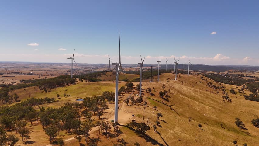 Wide aerial of multiple wind turbines spread across open countryside generating renewable energy, Cullerin resource development