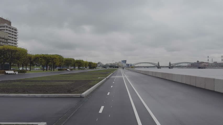 Empty Riverside Road and Cycling Path Along Neva River Under Cloudy Sky