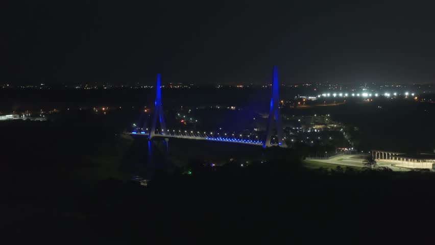 Integration Bridge Over Parana River And Marco das Tres Fronteiras At Night In Brazil. - aerial shot