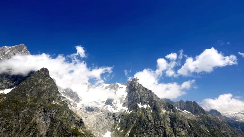 TIME LAPSE VIDEO Stunning aerial view of the snow-capped Mont Blanc massif with Aiguille Noire de Peuterey and glaciers under a clear blue sky 