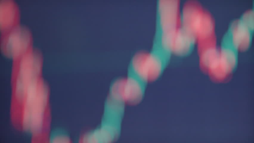 A close-up view of a Bitcoin coin resting on a keyboard, with a trading graph displayed in the background. The clip highlights the intersection of cryptocurrency and technology.