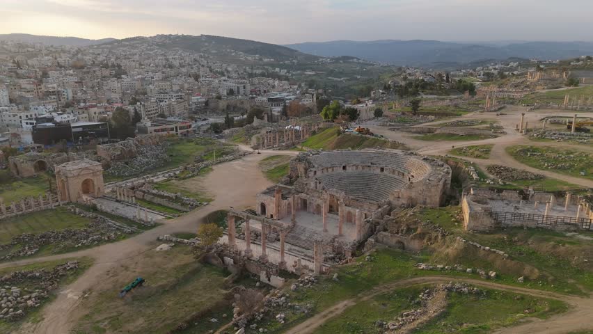 A breathtaking drone panorama looking over the well-preserved Roman ruins of Jerash, featuring the iconic columns and plazas as the sun rises, Jordan travel destination