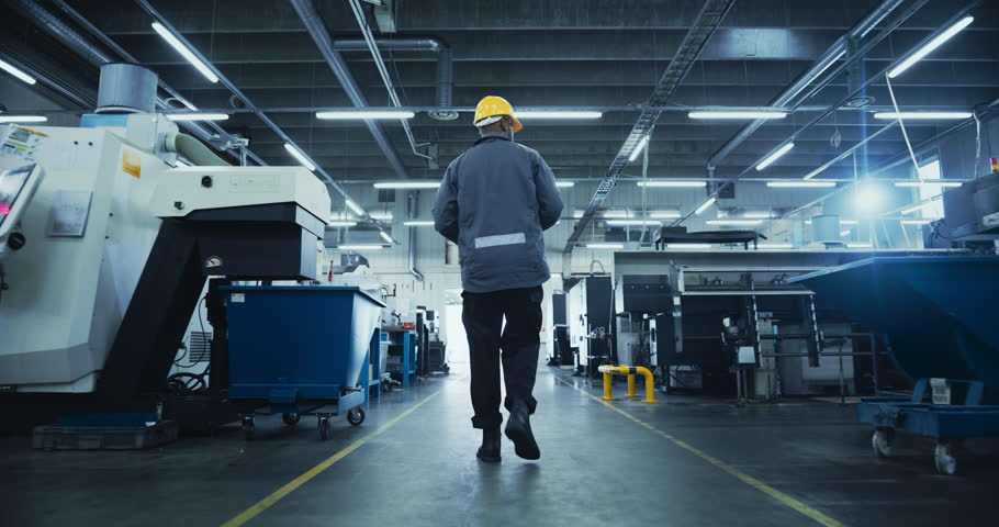 Factory Technician Walks in Manufacturing Facility with AI Data Overlays Scan Equipment, Digital Diagnostics. Visualization of Smart Machines, Monitoring Dashboards, Optimization of Production