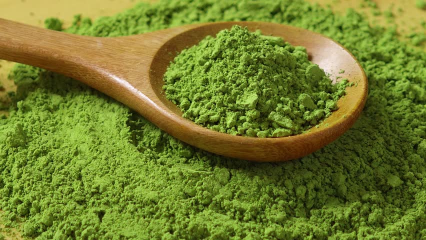 Matcha powder in a wooden spoon.	