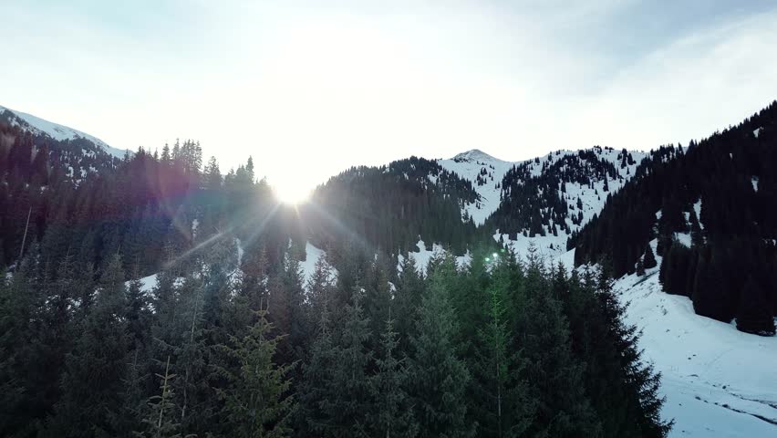 Man climbing frozen ice wall at winter mountains
