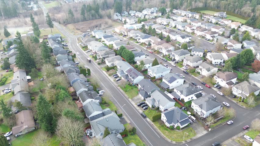 Outer subdivision streets sit near semi rural buffer along SE 272nd St where Kent meets Covington northern edge. Neutral roofs, clipped lawns, calm upscale residential area in Kent, Washington. USA