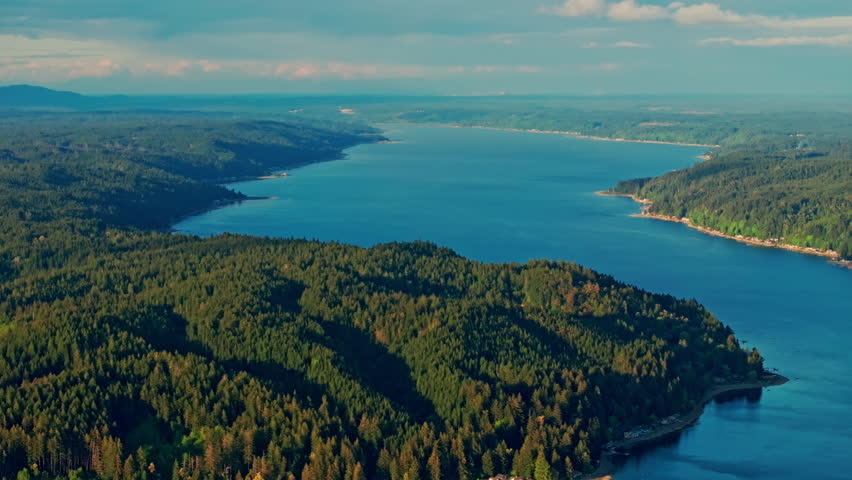 drone aerial of Hood Canal in Olympic National Park, Washington. Fjord-like coastline, calm water, evergreen forests and mountains define a serene Pacific Northwest landscape.