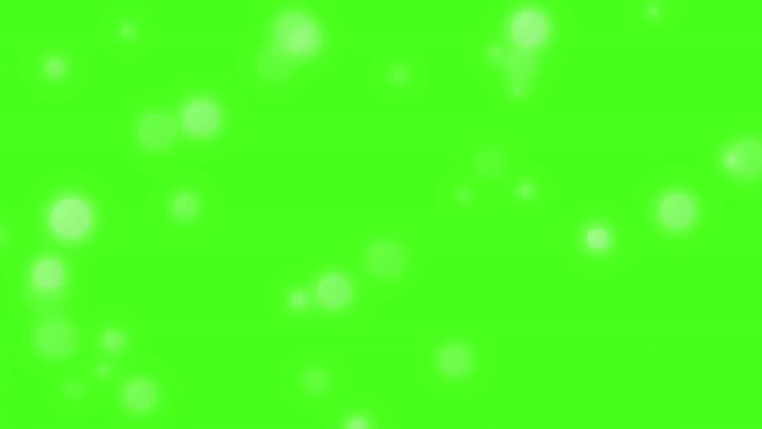 Floating white bokeh lights and particles on a green screen background. Soft, dreamy, and sparkling overlay for festive or magical scenes. Abstract light leaks and glitter