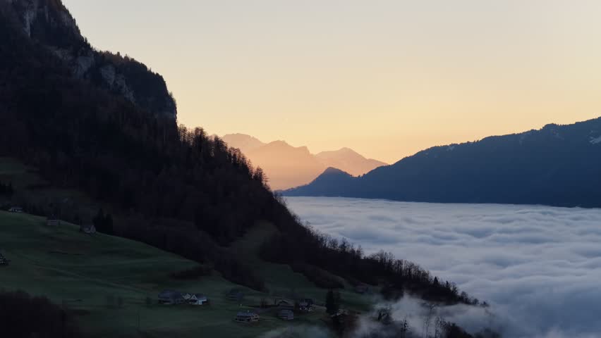 Peaceful sunrise above foggy Swiss Alps near Walensee lake