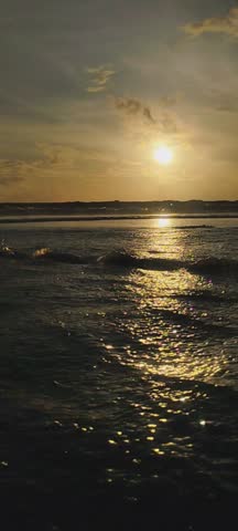 In the late afternoon, the sea transforms into a canvas of gold and amber. The sun hangs low above the horizon, casting a warm, glowing light that dances across the gentle waves. Each ripple reflects shades of orange, pink, and soft purple, blending seamlessly with the vast sky above.