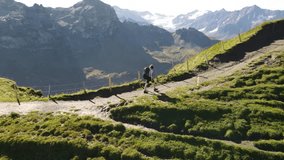 Backpacker hiking along a scenic mountain ridge in the Swiss Alps, high alpine trail with panoramic views, remote wilderness, Via Alpina route, summer hiking adventure Switzerland. Aerial drone view. - Powered by Shutterstock - Get 15% off with code: PIKWIZARD15