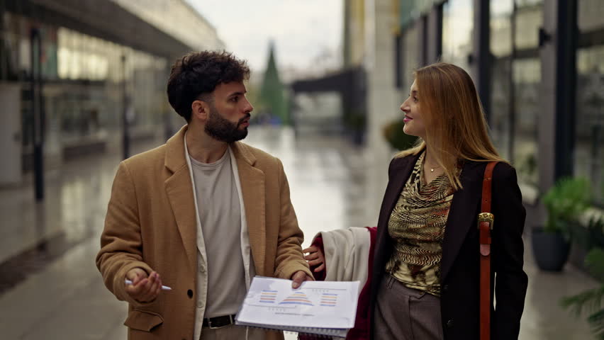 Two business people are engaging in a dynamic discussion, sharing insights and collaborating on new ideas while walking through a modern urban environment.
