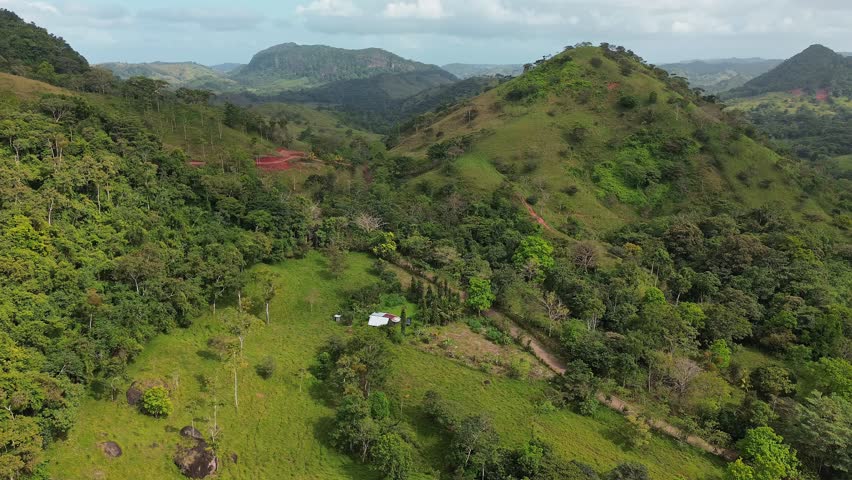 A lush green hillside with a white house in the middle