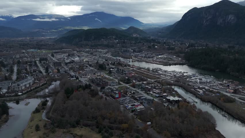 Town With Mountainous Background In Squamish, British Columbia, Canada. Aerial Wide Shot