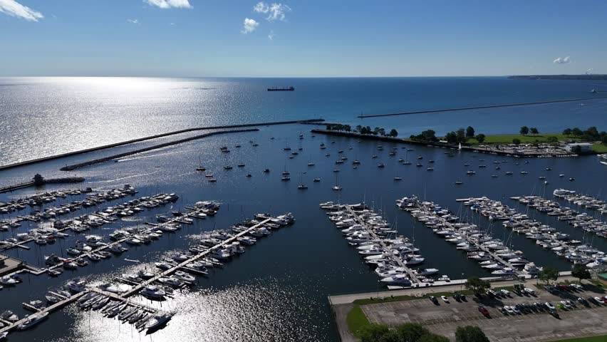 Aerial of Downtown Milwaukee Wisconsin on Labor Day Weekend.  Push shot of marina and sun reflection off Lake Michigan.  Boats docked in the harbor.