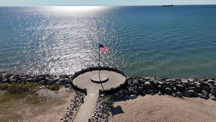 Aerial of Downtown Milwaukee Wisconsin on Labor Day Weekend.  Orbital drone shot of American Flag on beach off of Lake Michigan.