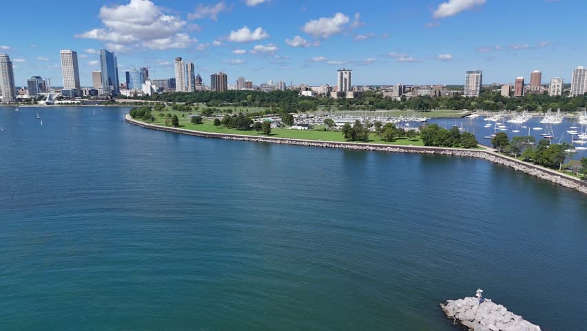 Aerial of Downtown Milwaukee Wisconsin on Labor Day Weekend.  Drone shot of blue water, clouds and skyline in the distance.